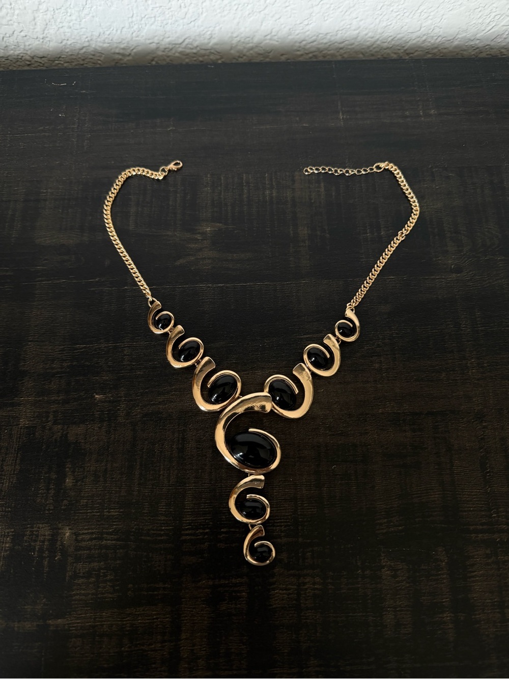 Gold-Tone Swirl Statement Necklace with Black Stones
